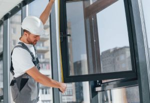 ouvrier qui mesure une fenêtre